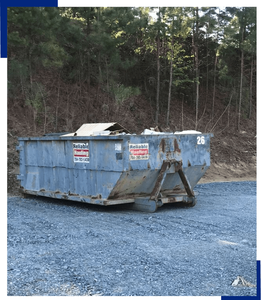 Large dumpster outdoors on gravel surface
