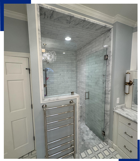 Marble-tiled glass shower with towel warmer